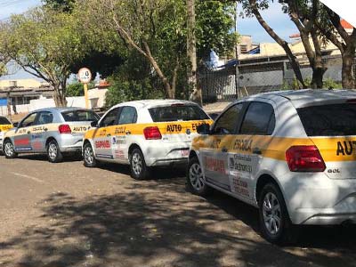 Carros para aulas práticas Carros brancos com faixa amarela da autoescola estacionados