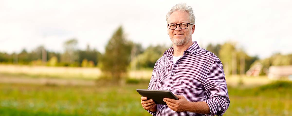 Soluções em internet para a zona rural Homem do campo segurando tablet