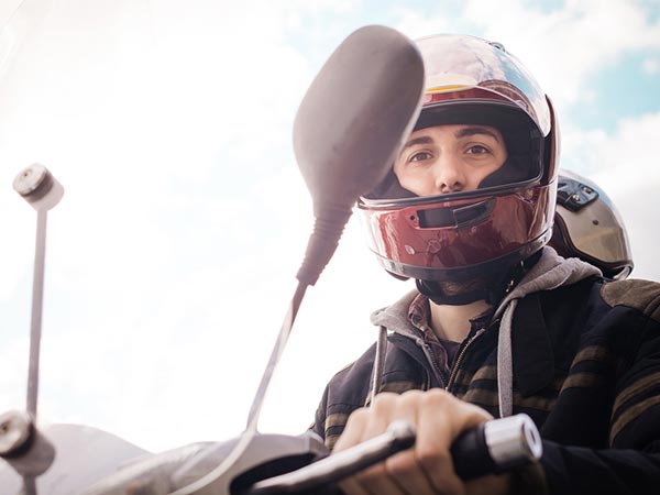 Habilitação para pilotar motos Jovem maior de idade pilotando uma moto