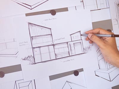 Projetos arquitetônicos residenciais e comerciais Engenheiro desenhando um projeto arquitetônico no papel