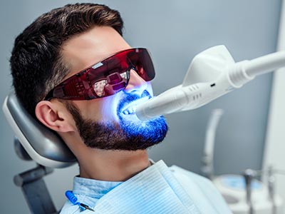 Diversos procedimentos para manter e melhorar a estética do sorriso Hoem fazendo clareamento dentário com laser