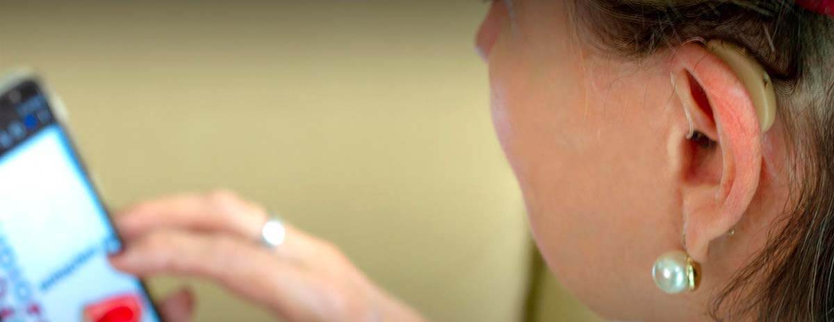 Recupere o prazer de ouvir com a Audiofocus Mulher usando aparelho auditivo