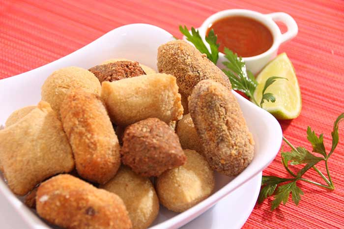 Coxinhas de frango para você se deliciar Prato com três coxinhas de frango