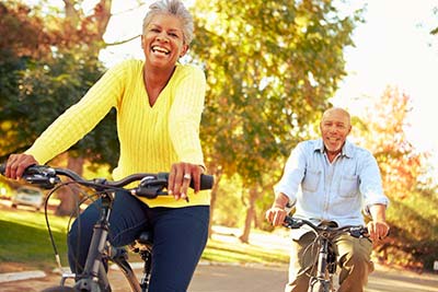Prática de atividades físicas na terceira idade Casal de idosos andando de bicicleta