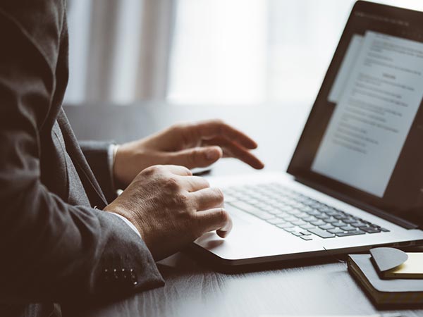 Abertura, alteração e encerramento de empresas Empresário digitando em notebook durante processo de abertura de empresa
