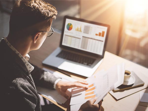 Escrituração fiscal e contábil Profissional analisando gráficos e relatórios contábeis no notebook