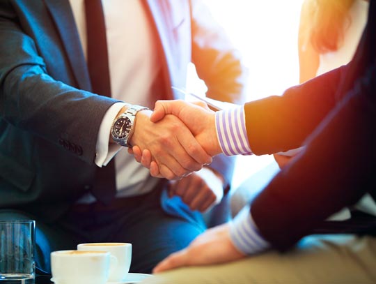 Assessoria empresarial Veiga Aperto de mãos entre empresário e consultor em reunião de assessoria empresarial