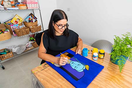 Cláudia Caffarena realizando atividade com arte