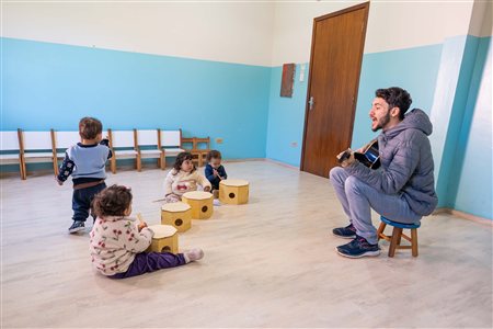 Aula de música com professor de violão e crianças