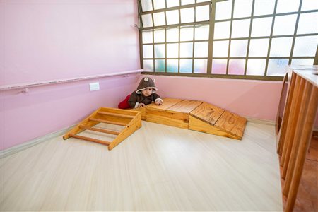 Bebê no triângulo de Pikler na sala materna