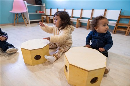 Nido — crianças com materiais na sala teal