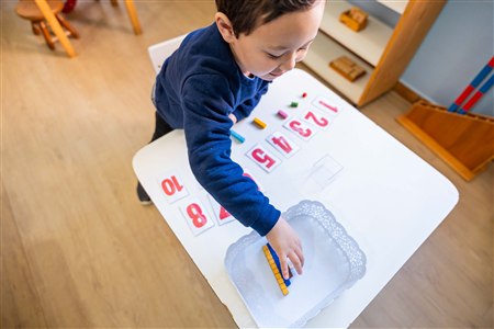 Infantil — criança trabalhando com materiais de números