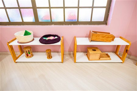 Prateleiras com materiais Montessori na sala Nido