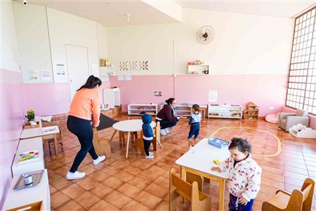 Sala materna com professoras e crianças