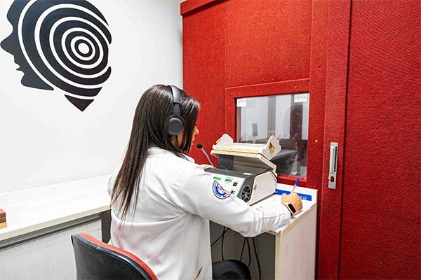 Exame de audiometria Profissional realizando exame de audiometria em cabine