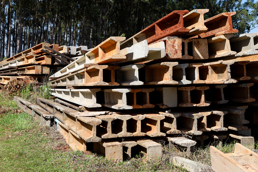 Postes de concreto Duplo T empilhados no pátio da Lahos Postes