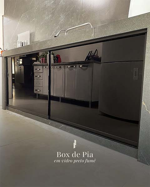 Box de pia em vidro preto fumê fechando o vão sob a bancada da cozinha