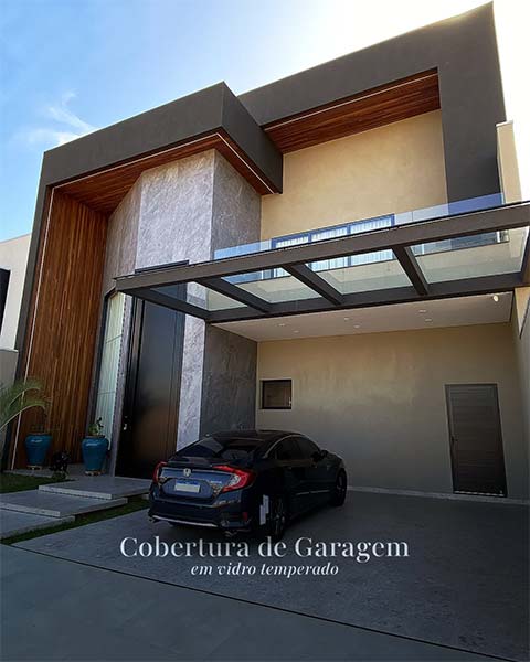 Cobertura de garagem em vidro temperado na fachada de uma residência