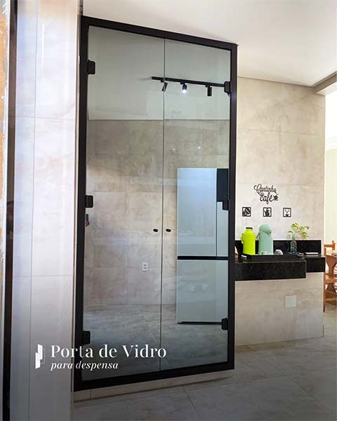 Porta de vidro com perfil preto instalada na despensa de uma cozinha