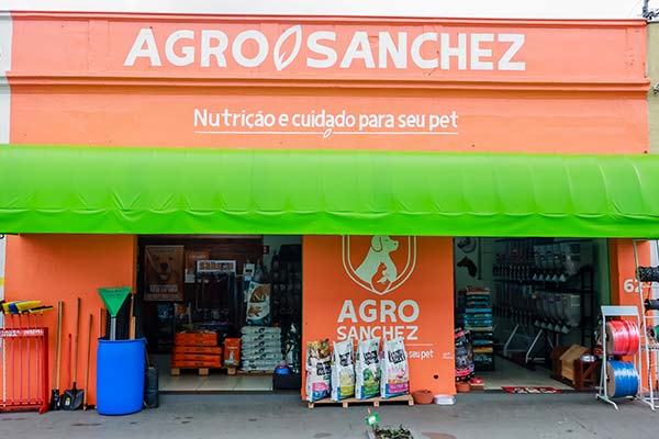 Loja Agro Sanchez em Birigui Fachada da loja Agro Sanchez em Birigui com toldo verde e produtos expostos