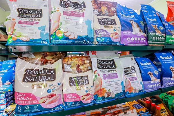 Rações para cães e gatos na Agro Sanchez Prateleira com sacos de ração super premium para cães de diversas marcas