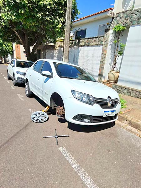 Troca de pneu de carro Carro sem a roda durante troca de pneu na rua
