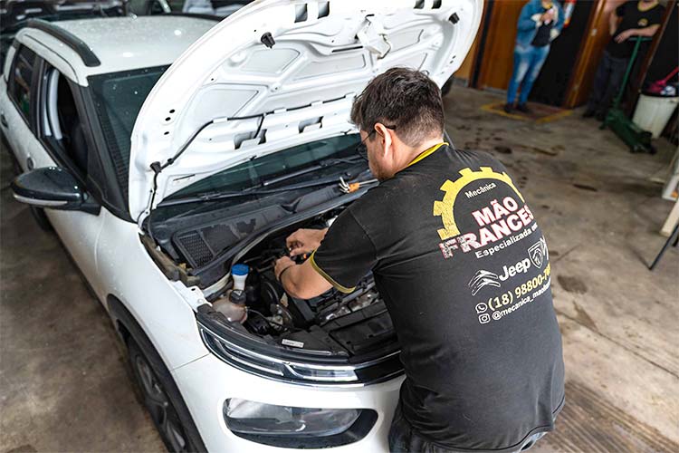 Mecânico trabalhando no compartimento do motor de um veículo