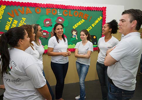 Alunas e professor do IEA conversando no pátio da escola