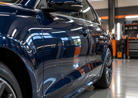 Detalhe da lateral de automóvel azul com pintura brilhante